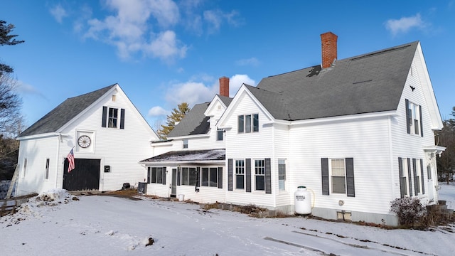 1153 Dexter Rd, Dover-Foxcroft, ME 04426 - snow covered rear of property featuring a sunroom, a chimney, and a garage
