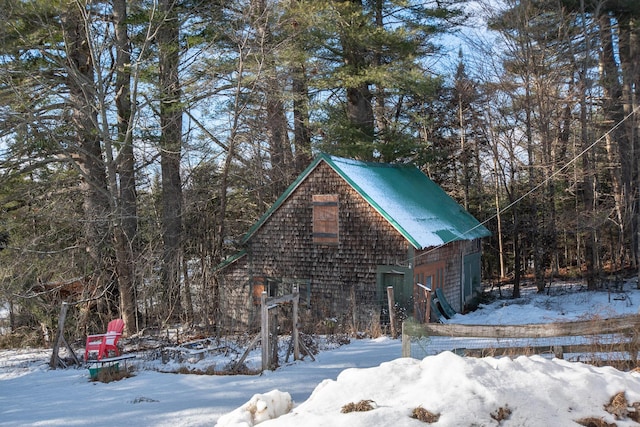 1153 Dexter Rd, Dover-Foxcroft, ME 04426 - view of snow covered exterior featuring an attached garage and a metal roof