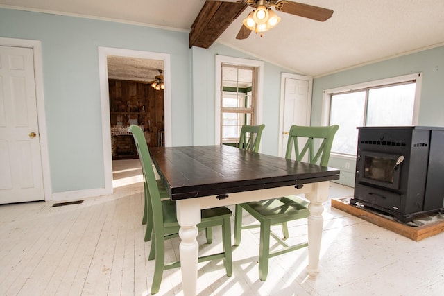 1153 Dexter Rd, Dover-Foxcroft, ME 04426 - dining room featuring a ceiling fan, light wood-style flooring, a wood stove, plenty of natural light, and crown molding