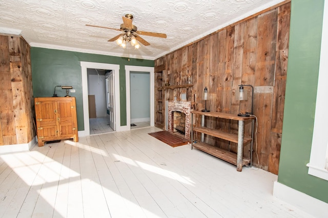 1153 Dexter Rd, Dover-Foxcroft, ME 04426 - unfurnished living room with a ceiling fan, wooden walls, an ornate ceiling, and wood finished floors