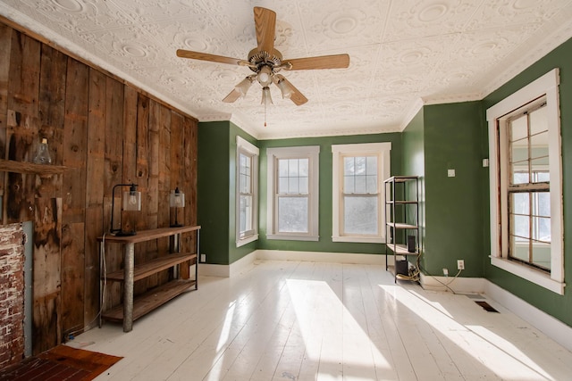 1153 Dexter Rd, Dover-Foxcroft, ME 04426 - unfurnished living room with a ceiling fan, ornamental molding, wood finished floors, an ornate ceiling, and wood walls