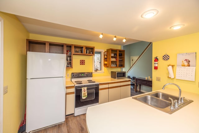 kitchen featuring kitchen peninsula, white appliances, sink, and light hardwood / wood-style flooring