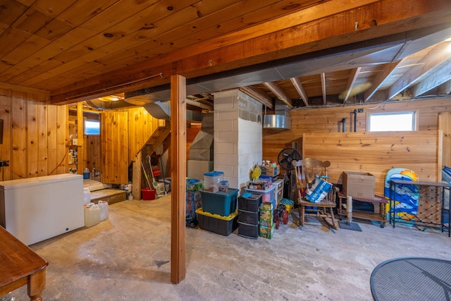 basement with wood walls and fridge