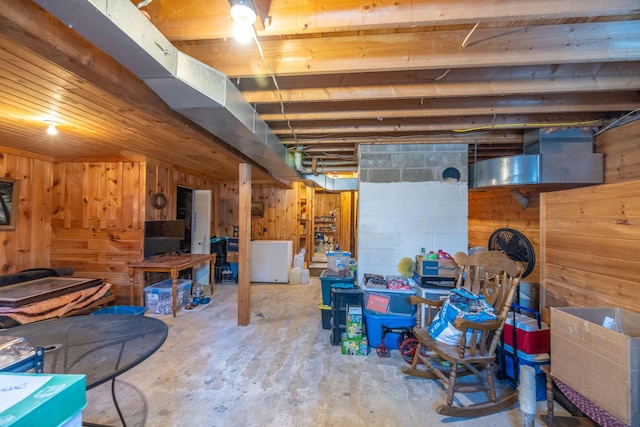 basement with wood walls and refrigerator