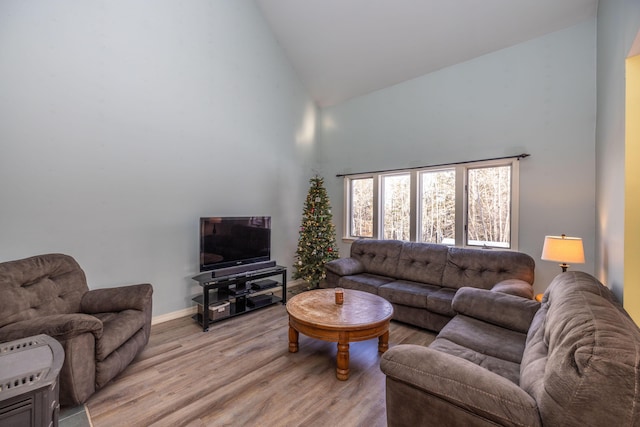 living room featuring high vaulted ceiling and light wood-type flooring