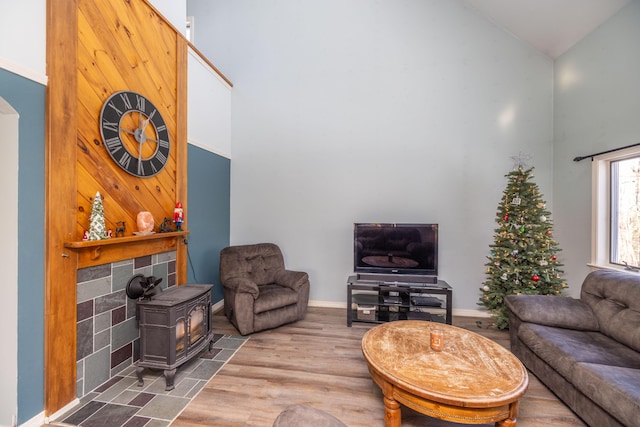 living room with a wood stove and high vaulted ceiling