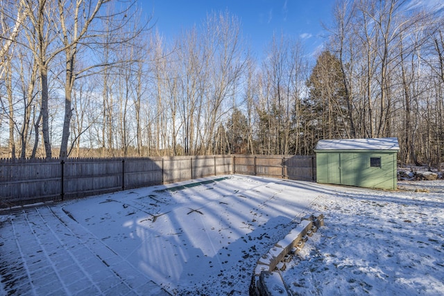 yard covered in snow with a storage unit