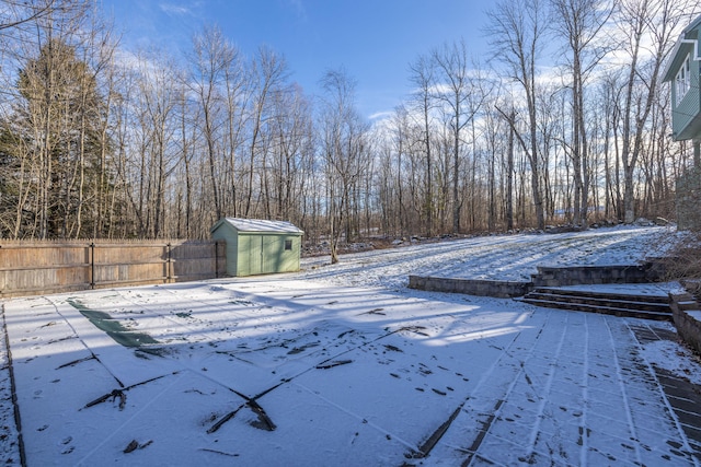 snowy yard with a storage shed