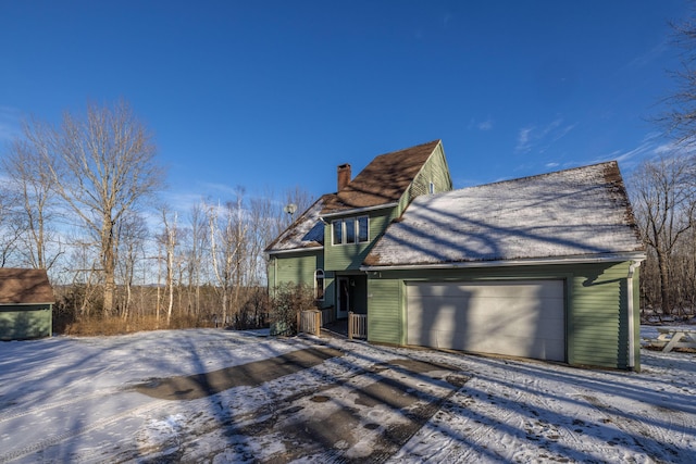 view of snowy exterior featuring a garage