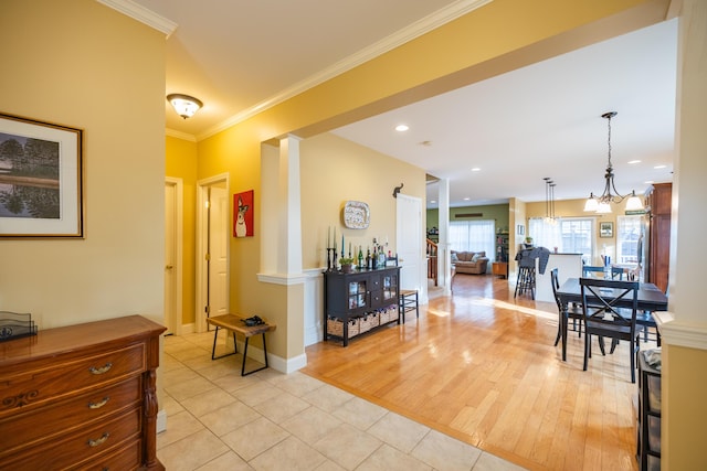 interior space featuring a notable chandelier, light wood-type flooring, and crown molding