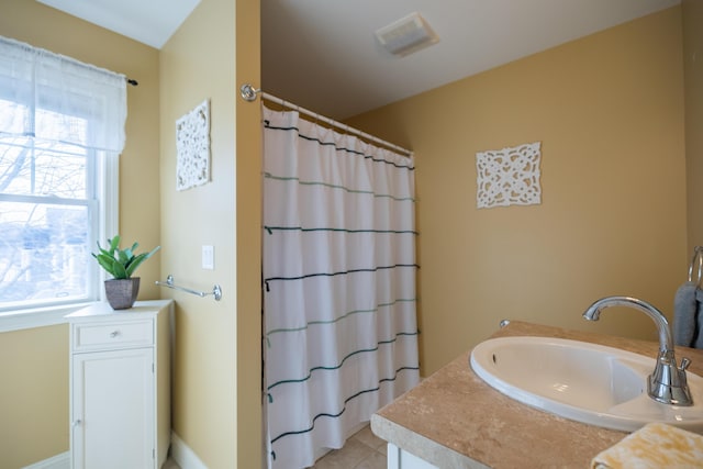 bathroom with vanity, tile patterned floors, a healthy amount of sunlight, and walk in shower