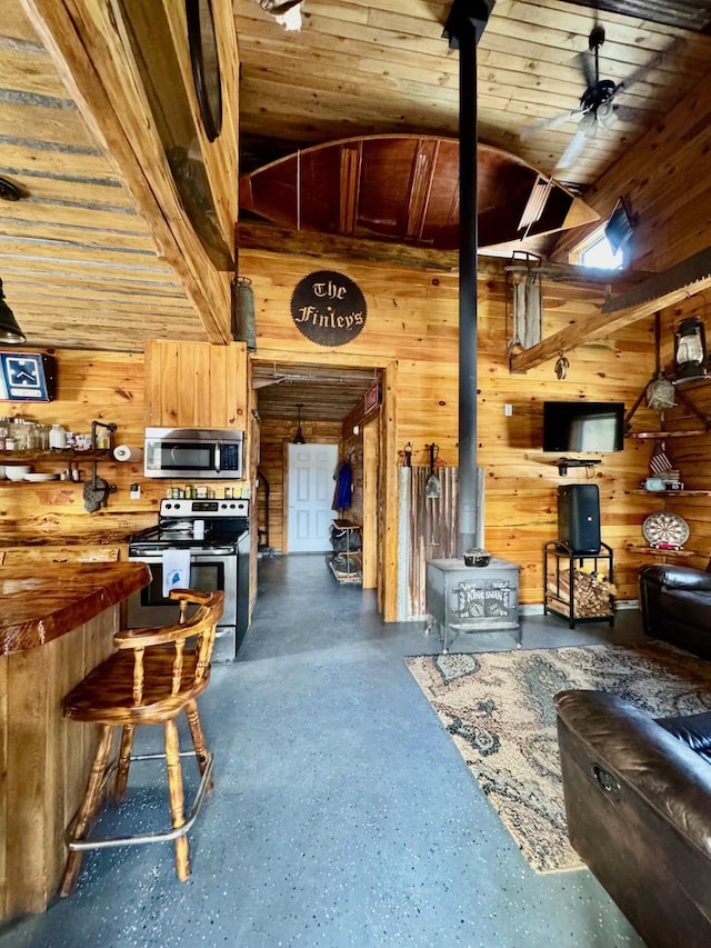 154 Old Brownville Rd, Sebec, ME 04481 - living area with a wood stove, wood walls, and wooden ceiling
