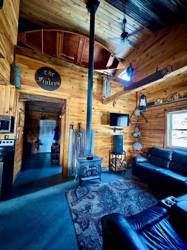 154 Old Brownville Rd, Sebec, ME 04481 - living area with a wood stove, wood walls, and finished concrete floors