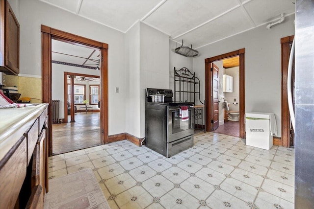 kitchen with ceiling fan, stainless steel range with electric stovetop, and radiator