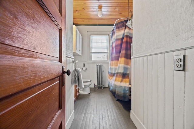 bathroom with toilet, hardwood / wood-style flooring, wood walls, radiator, and wood ceiling