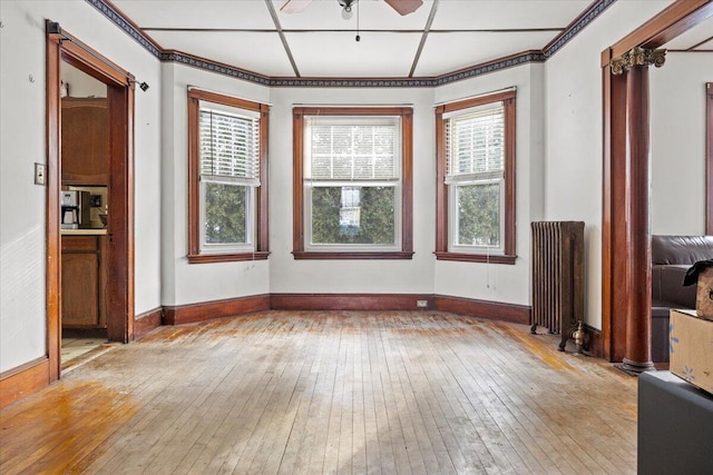 unfurnished living room featuring ceiling fan, light wood-type flooring, and radiator