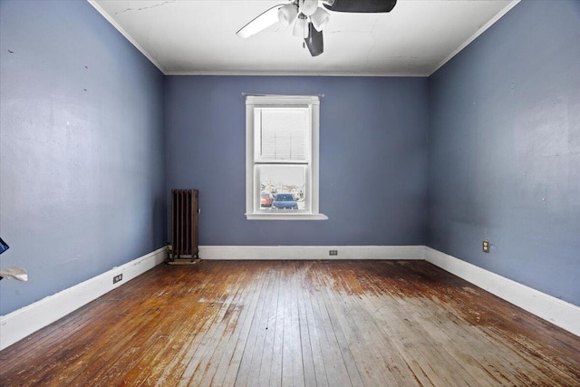 empty room featuring ornamental molding, ceiling fan, radiator heating unit, and wood-type flooring