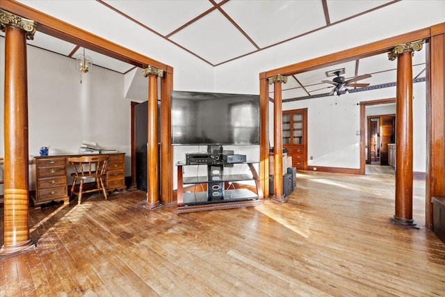 interior space with ornate columns, hardwood / wood-style floors, and ceiling fan