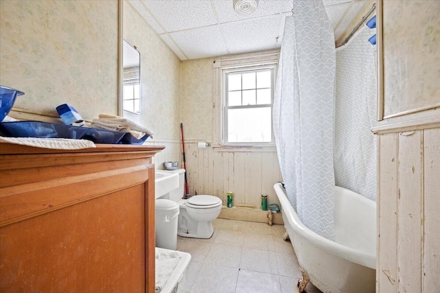 bathroom featuring a paneled ceiling and toilet