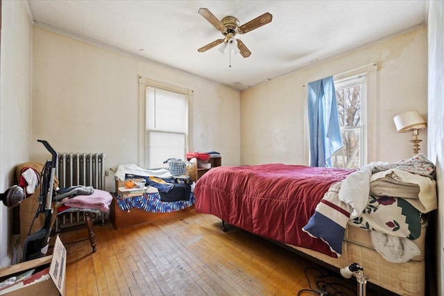 bedroom featuring radiator, hardwood / wood-style floors, and ceiling fan