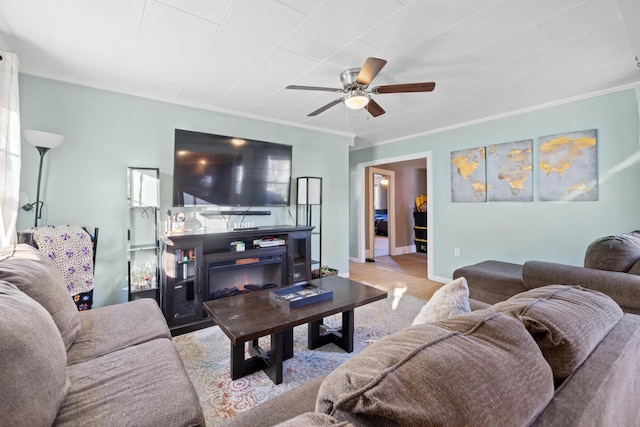 living room featuring ceiling fan, light wood-type flooring, and ornamental molding