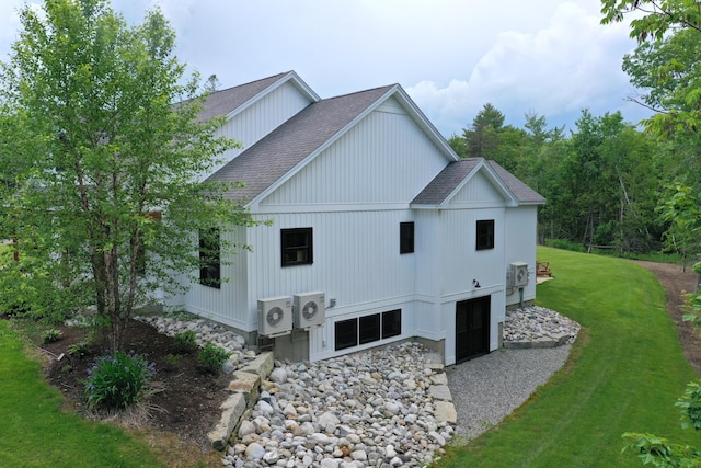 view of side of property featuring ac unit and a yard