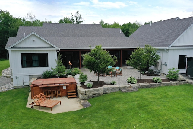 back of house featuring a lawn, a bar, a patio, and a hot tub