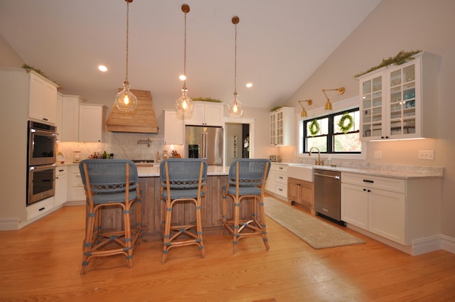 kitchen with a center island, stainless steel appliances, white cabinetry, and tasteful backsplash