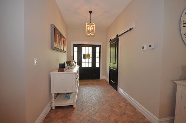 entryway featuring a barn door and a notable chandelier