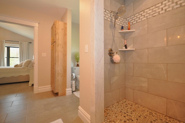 bathroom featuring a tile shower and toilet