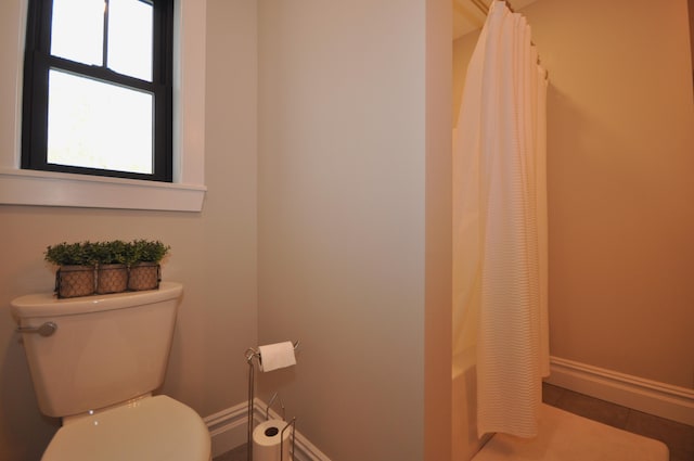 bathroom featuring toilet and shower / bath combo with shower curtain