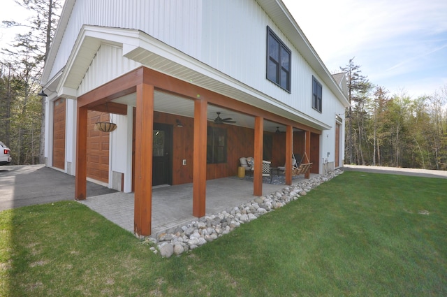 view of side of property with ceiling fan, a yard, and a patio