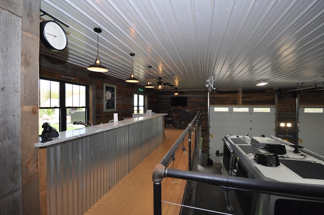 garage featuring ceiling fan and wooden walls