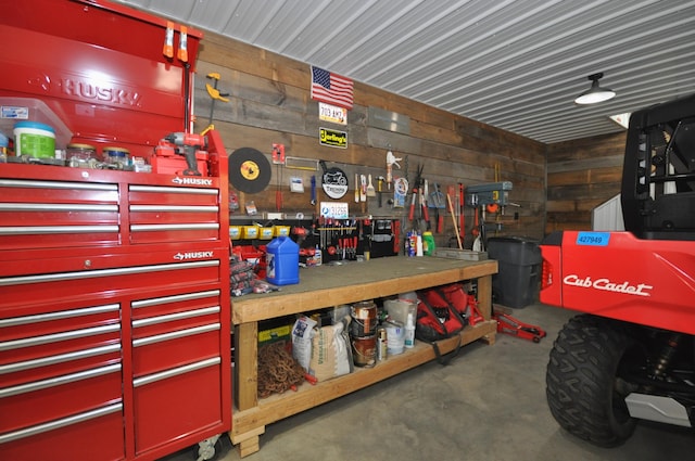 misc room with a workshop area and wooden walls