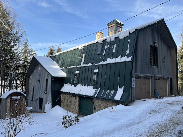 view of snowy exterior with a garage