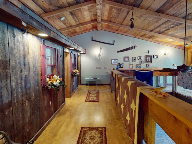 interior space featuring wooden walls, lofted ceiling with beams, wooden ceiling, and light wood-type flooring