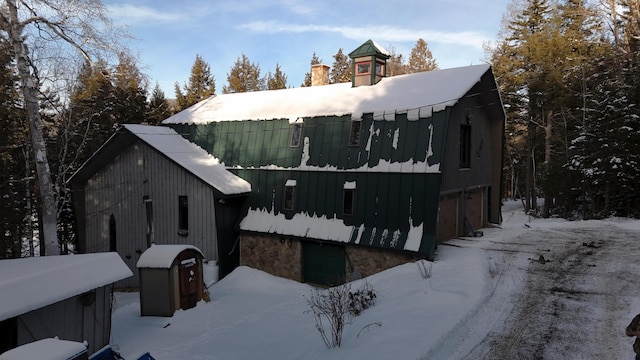 snow covered property with a garage