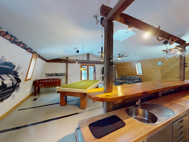 game room featuring vaulted ceiling, sink, tile patterned floors, and wood walls