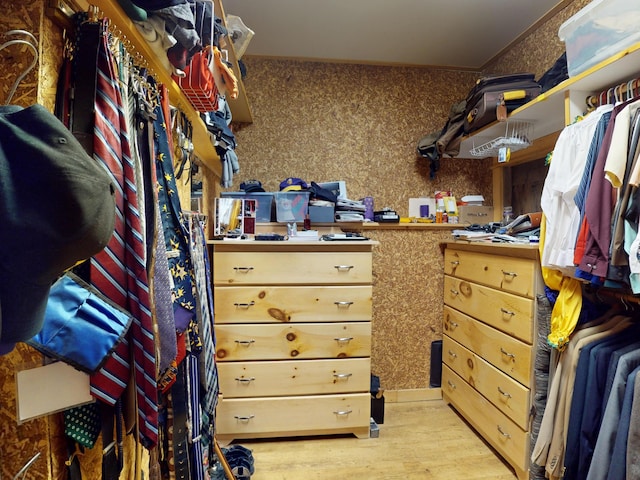 walk in closet with light hardwood / wood-style floors