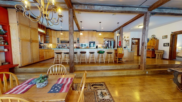 dining room featuring an inviting chandelier, light hardwood / wood-style floors, and beamed ceiling