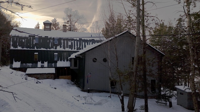 view of snow covered back of property