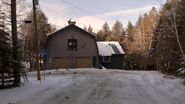 view of snowy exterior featuring a garage