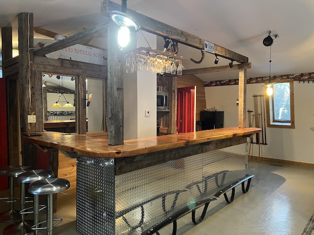 bar featuring concrete floors, wooden counters, and black fridge