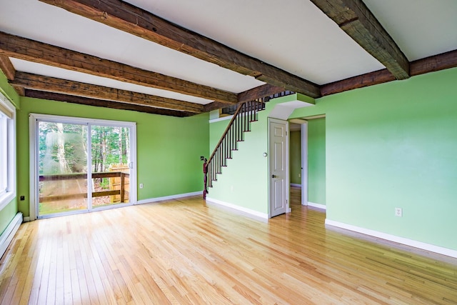 unfurnished living room featuring beam ceiling, light hardwood / wood-style floors, and baseboard heating