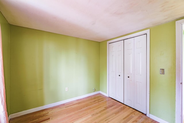 unfurnished bedroom with a closet and light hardwood / wood-style floors