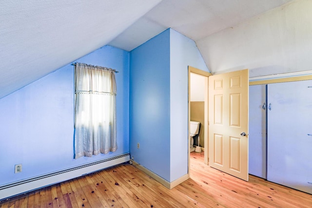 bonus room featuring lofted ceiling, baseboard heating, and light hardwood / wood-style flooring