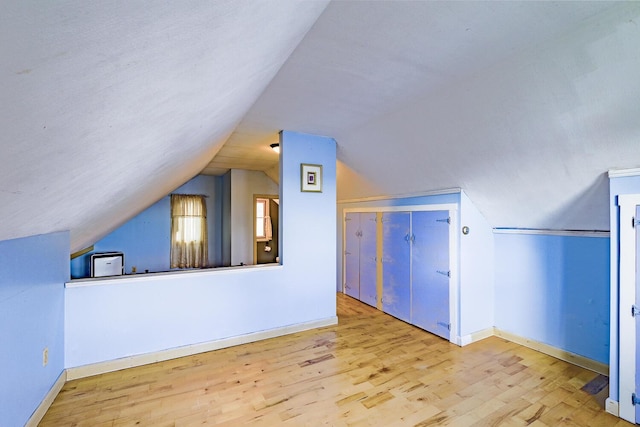 bonus room featuring light hardwood / wood-style floors and lofted ceiling