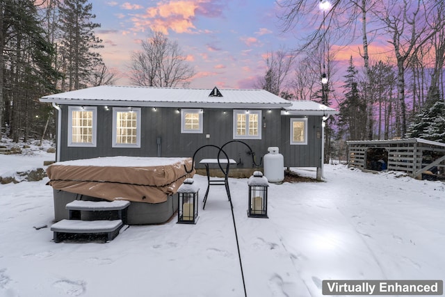 snow covered property with a hot tub