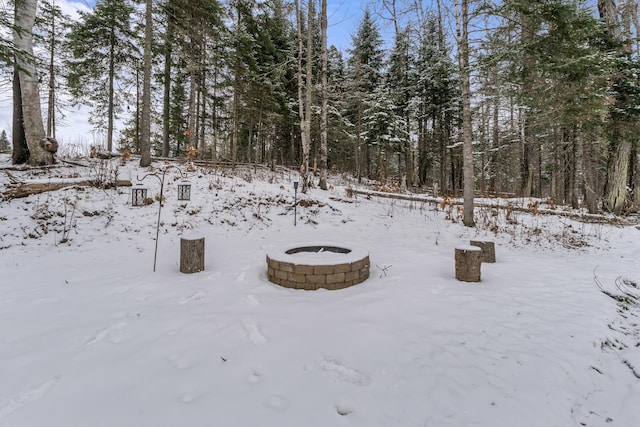 yard covered in snow with an outdoor fire pit