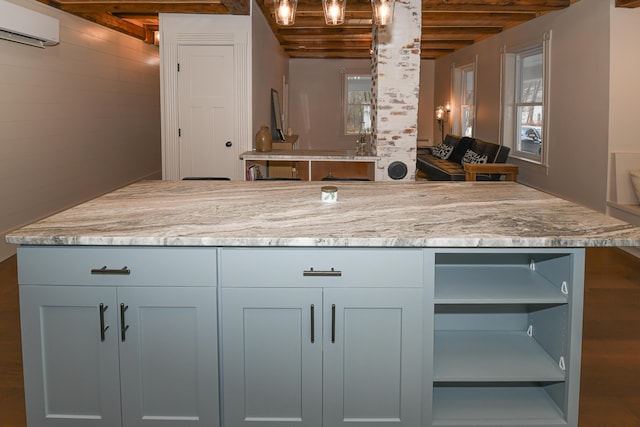 20 N High St, Bridgton, ME 04009 - kitchen with light stone countertops, beam ceiling, a wall unit AC, and a wealth of natural light